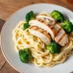 A comforting plate of ziti pasta with tender chicken and sautéed broccoli, served with a flavorful sauce.
